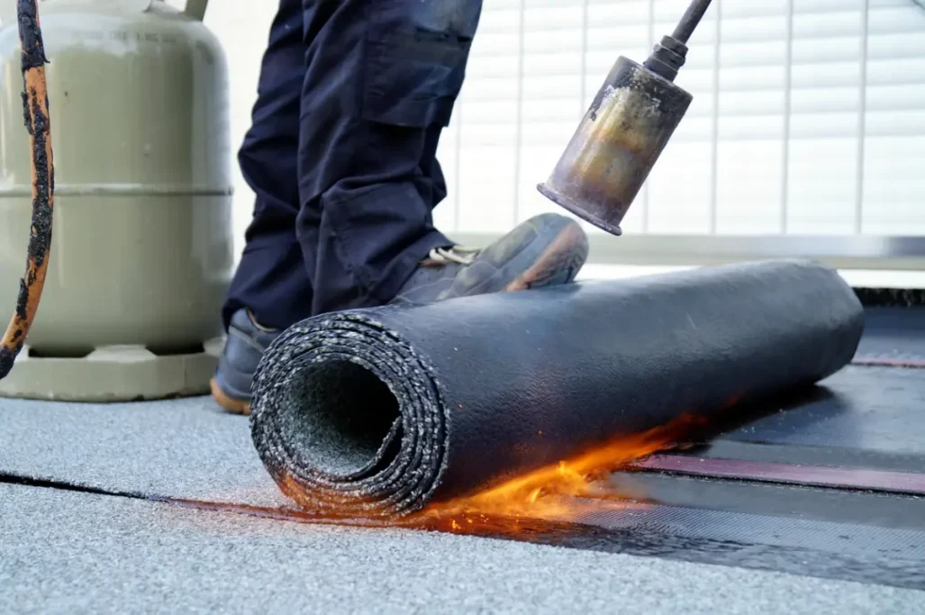 Bitumen-Abdichtungen Foto zeigt die Verlegung einer Bitumen-Bahn mit Hilfe eines Brenners (Verschweißen)